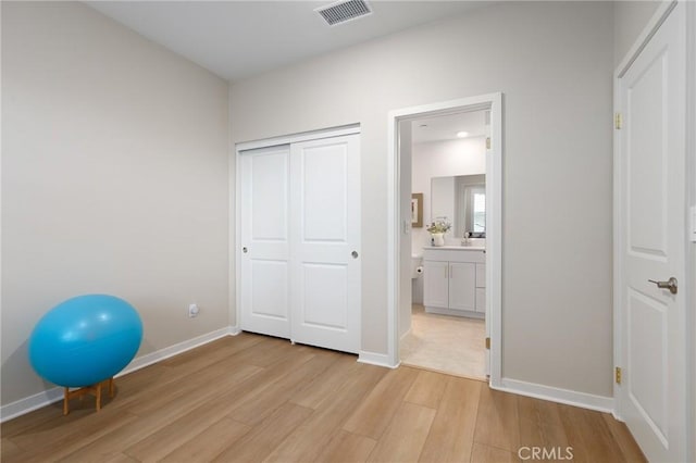 exercise room with light wood-type flooring