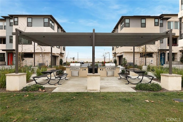 surrounding community featuring exterior kitchen, a lawn, a patio area, and a pergola