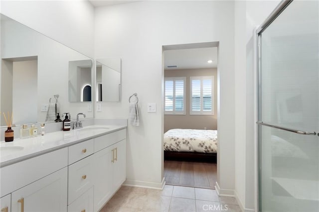 bathroom featuring tile patterned flooring, vanity, and a shower with door