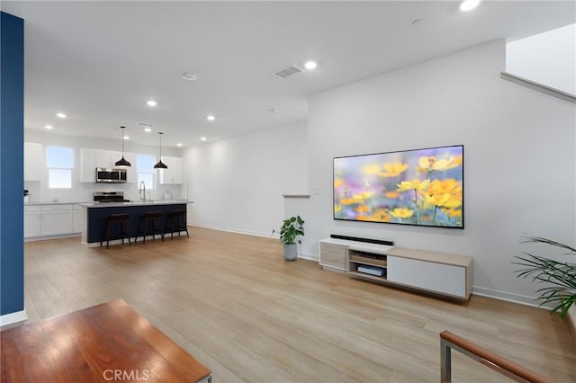 living room featuring sink and light wood-type flooring