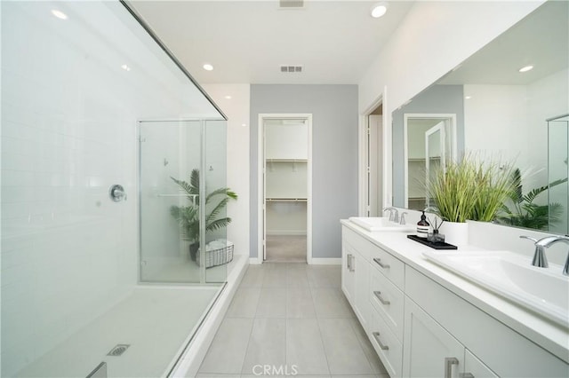 bathroom with tile patterned flooring, vanity, and a shower with shower door