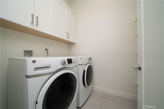 laundry room featuring cabinets, separate washer and dryer, and light tile patterned floors