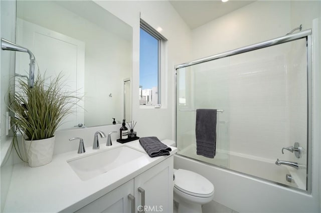 full bathroom featuring vanity, enclosed tub / shower combo, and toilet