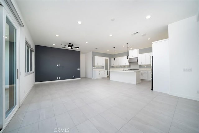 unfurnished living room featuring sink and ceiling fan