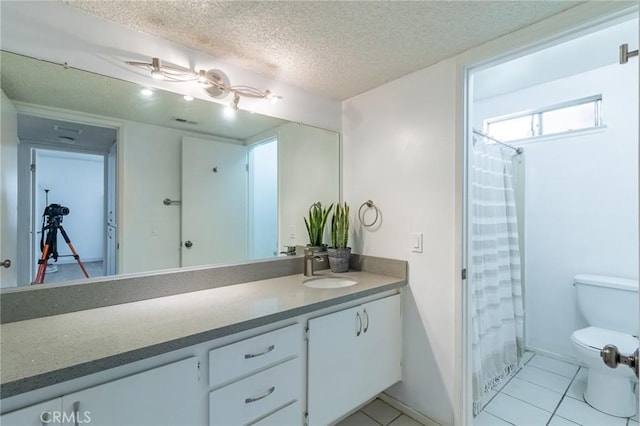 bathroom with vanity, tile patterned floors, a textured ceiling, and toilet