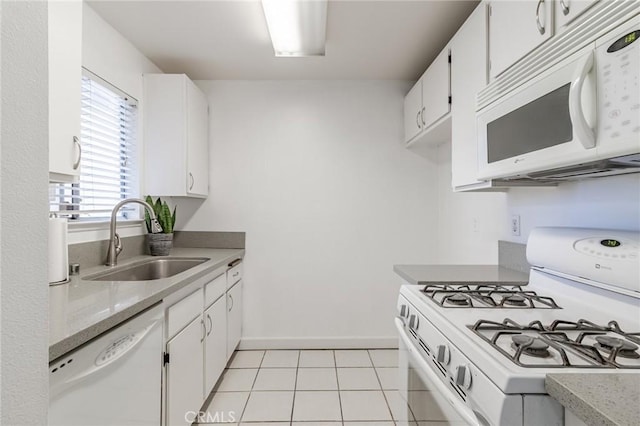 kitchen with white cabinetry, sink, white appliances, and light tile patterned floors