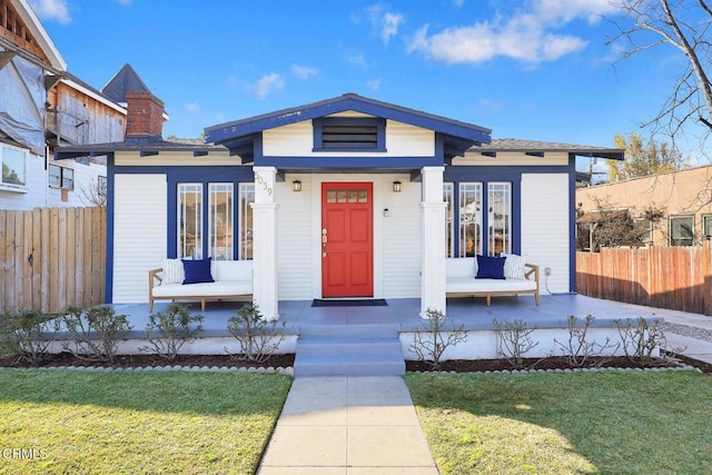 view of front of house with a front yard and covered porch