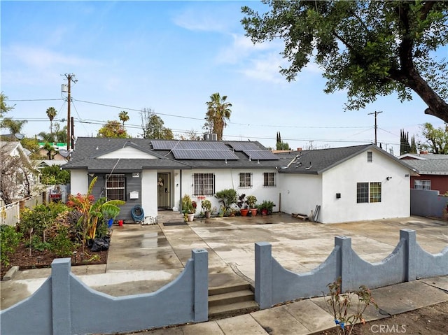 rear view of house featuring solar panels