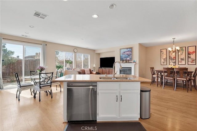 kitchen with light wood-style floors, visible vents, dishwasher, and a sink