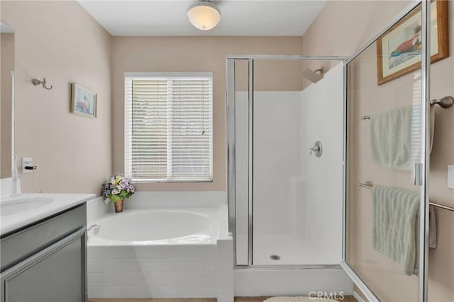 bathroom with a stall shower, a garden tub, and vanity