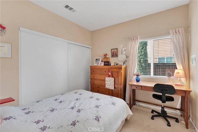 bedroom with light carpet, visible vents, and a closet