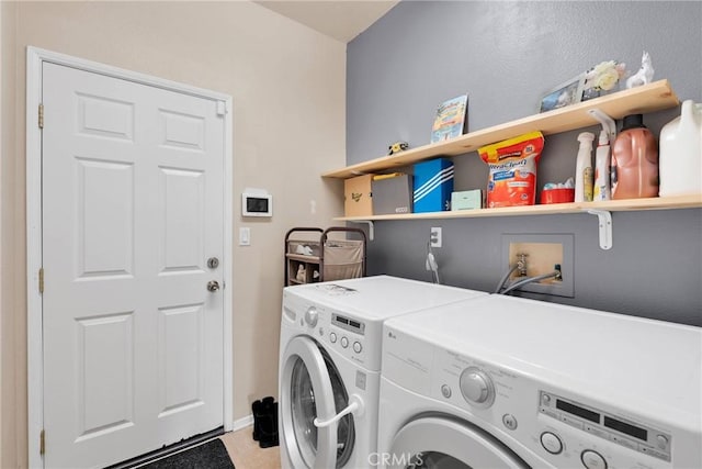 clothes washing area with light tile patterned floors, laundry area, and washing machine and clothes dryer