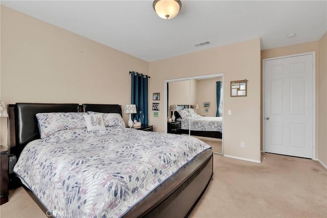 bedroom with light carpet, a closet, visible vents, and baseboards