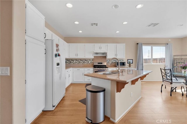 kitchen with appliances with stainless steel finishes, visible vents, a sink, and under cabinet range hood