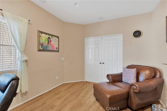 living area featuring light wood-style flooring and baseboards