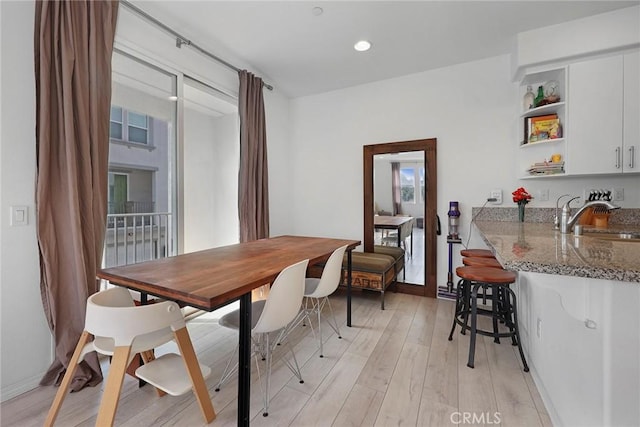 dining room with sink and light hardwood / wood-style flooring