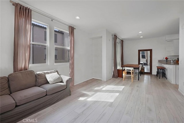 living room featuring sink and light hardwood / wood-style flooring