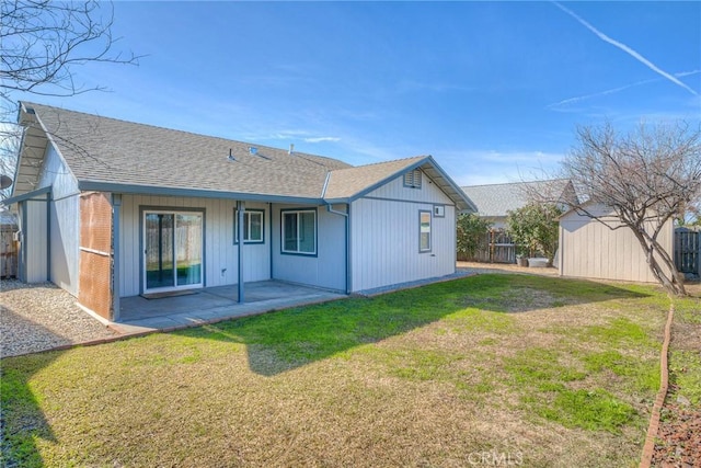 back of house with a shed, a lawn, and a patio