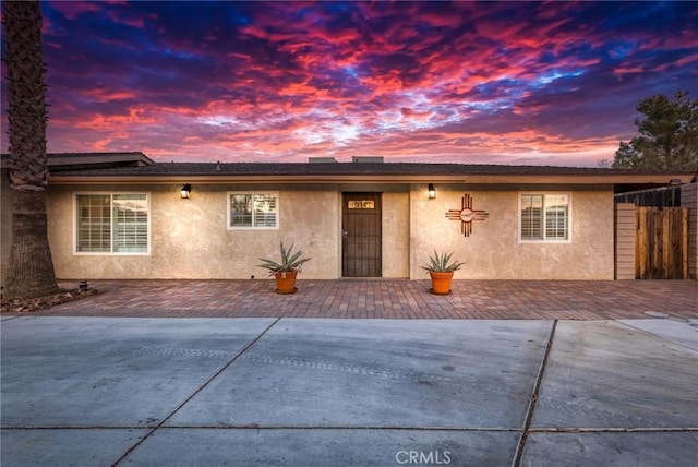 single story home featuring a patio area, fence, and stucco siding