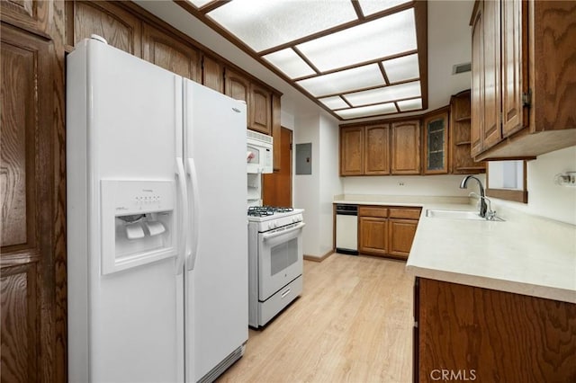 kitchen with white appliances, electric panel, sink, and light wood-type flooring