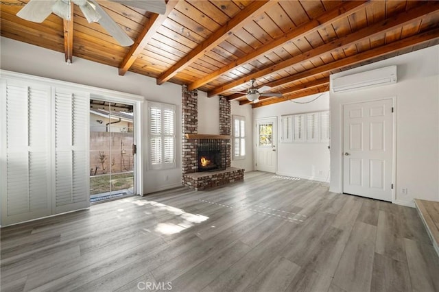 unfurnished living room featuring wooden ceiling, an AC wall unit, hardwood / wood-style flooring, ceiling fan, and a fireplace