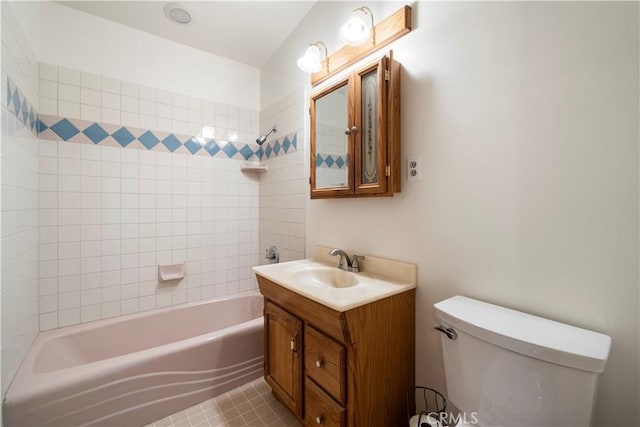 full bathroom with vanity, tiled shower / bath, and toilet