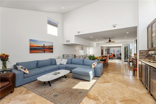 living room featuring a towering ceiling and ceiling fan