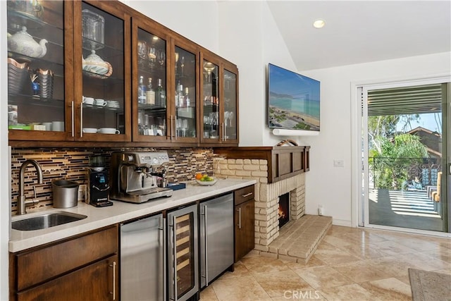 bar with stainless steel refrigerator, vaulted ceiling, sink, and backsplash