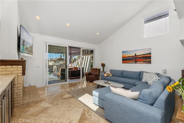 living room with a fireplace and high vaulted ceiling