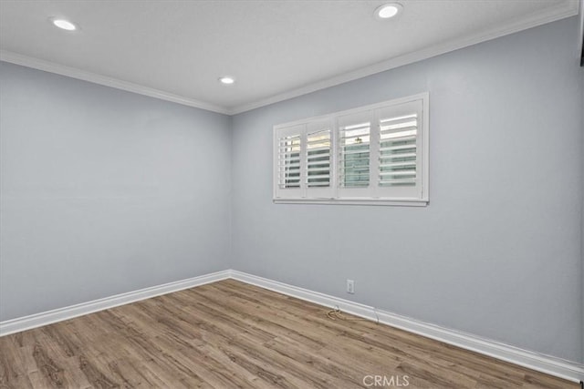 unfurnished room with hardwood / wood-style floors and crown molding