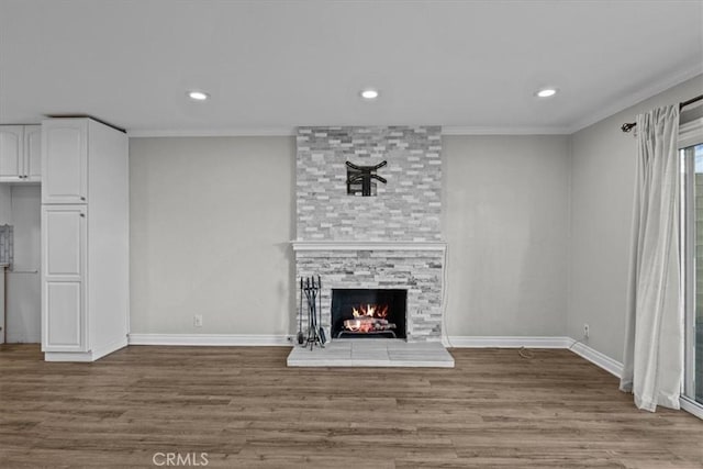 unfurnished living room with crown molding, a fireplace, and hardwood / wood-style flooring