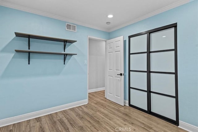 interior space with light hardwood / wood-style flooring and ornamental molding