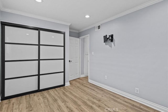 unfurnished bedroom featuring crown molding and light hardwood / wood-style floors