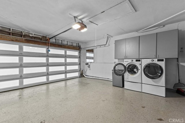 garage with a garage door opener and independent washer and dryer