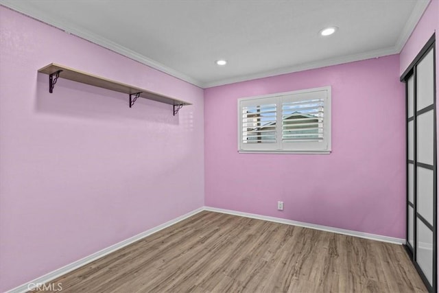 spare room featuring light hardwood / wood-style flooring and ornamental molding