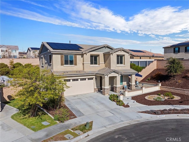 view of front of property with a garage and solar panels