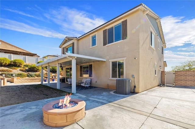 rear view of house featuring a patio, a pergola, central AC unit, and a fire pit