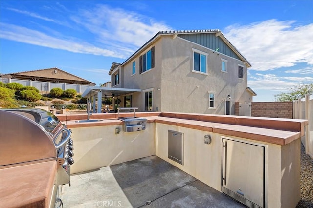 exterior space featuring sink, a patio area, and an outdoor kitchen