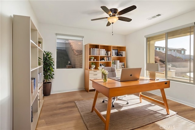 home office featuring ceiling fan and light hardwood / wood-style flooring