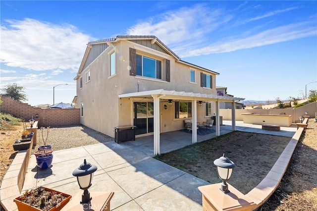 rear view of house with a pergola, a jacuzzi, and a patio