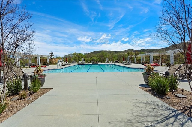 view of pool featuring a mountain view, a pergola, and a patio area