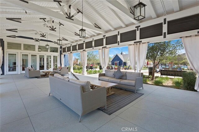 sunroom / solarium with french doors, plenty of natural light, and lofted ceiling with beams