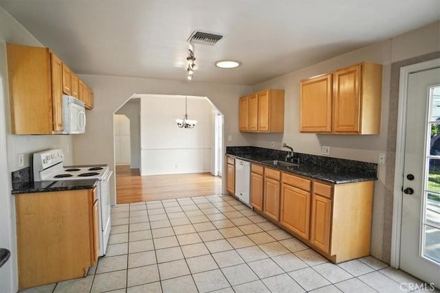 kitchen with sink, hanging light fixtures, light tile patterned floors, dark stone countertops, and white appliances