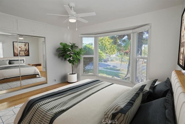 bedroom with light hardwood / wood-style floors and ceiling fan