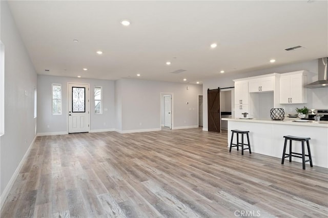 interior space featuring sink, light hardwood / wood-style floors, and a barn door