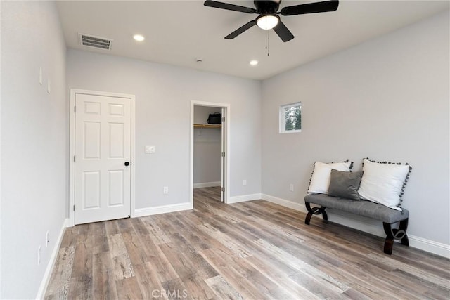 living area featuring light hardwood / wood-style flooring and ceiling fan