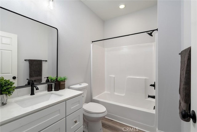 full bathroom featuring vanity, hardwood / wood-style floors, shower / bathtub combination, and toilet