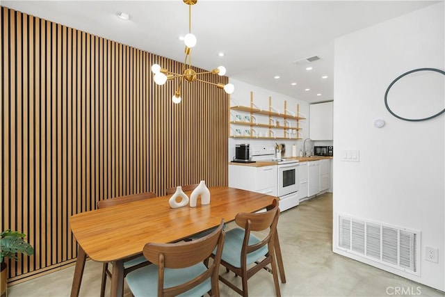 dining area with recessed lighting, visible vents, concrete flooring, and a chandelier