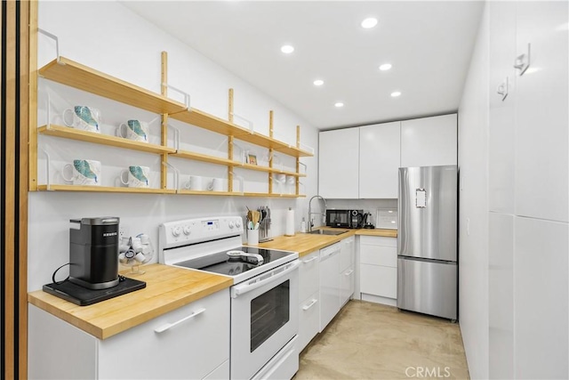 kitchen featuring a sink, butcher block counters, white cabinets, white appliances, and open shelves