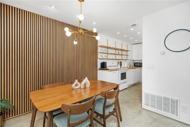 dining area featuring recessed lighting, visible vents, concrete floors, and an inviting chandelier